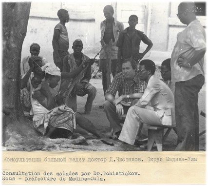Image in black and white of people in consultation in Madina Oula 