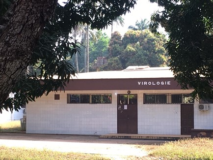 Photo of a building with the word virologie on it situated among trees