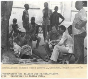 Image in black and white of people in consultation in Madina Oula